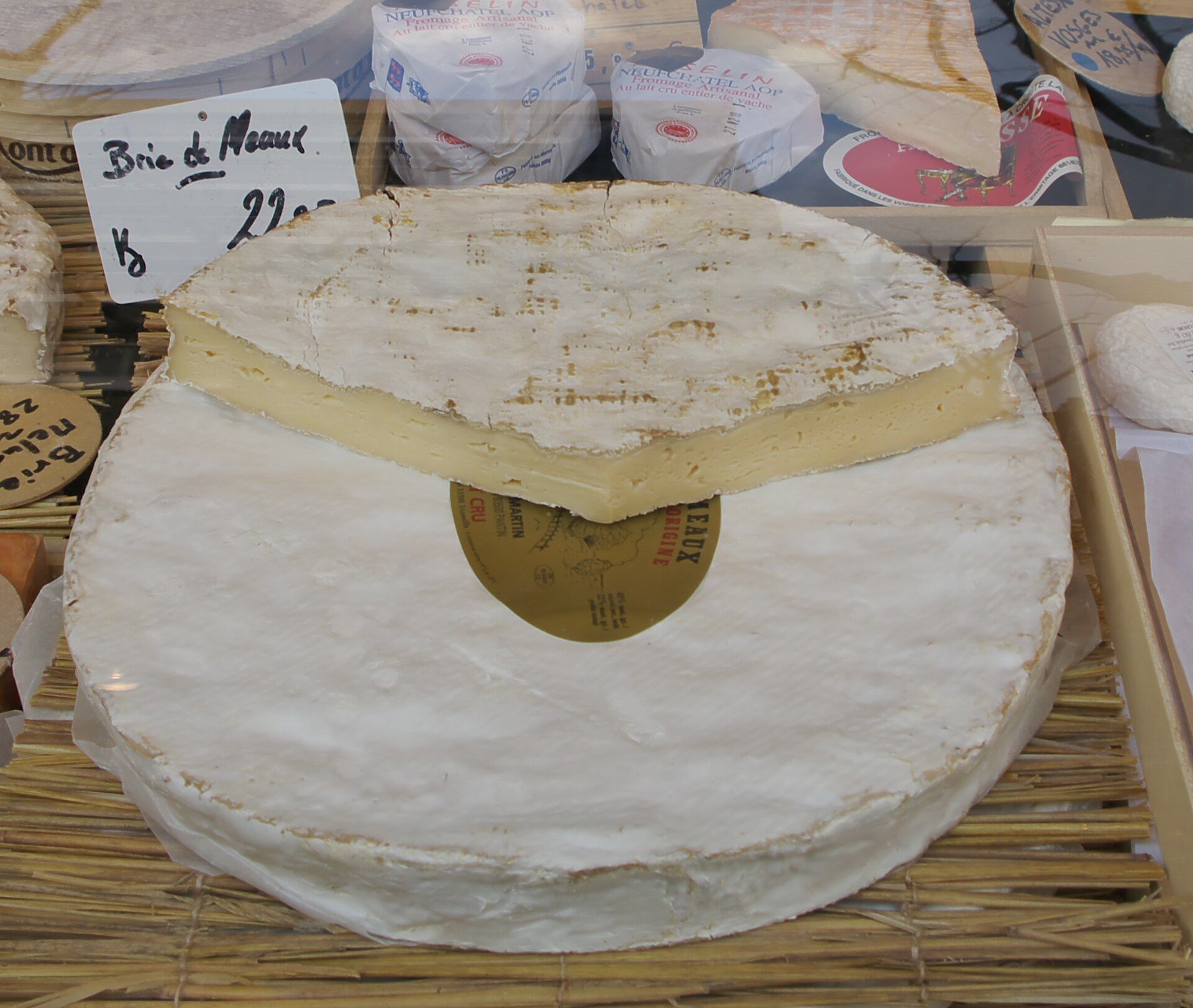 Bir Fransız pazarında hasır üstünde kesilmiş Brie de Meaux